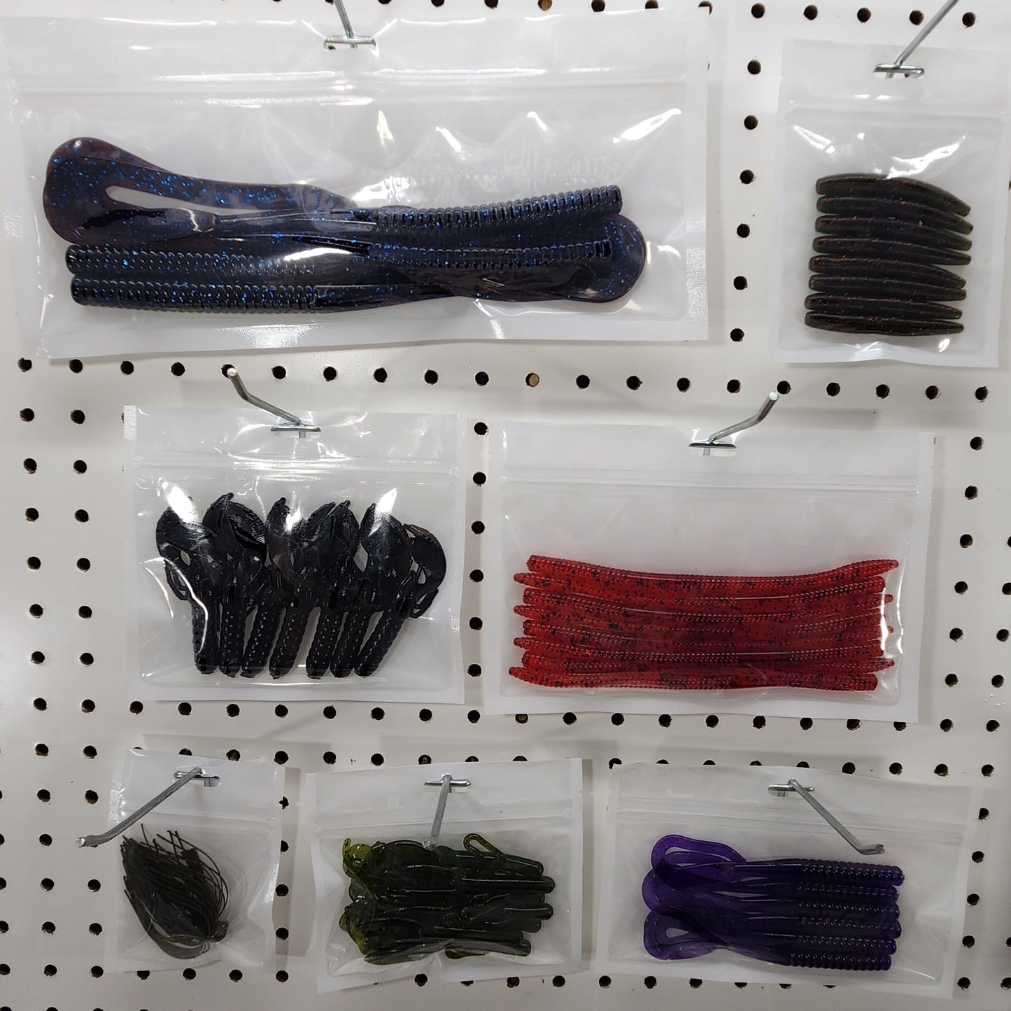 Clear and white laminated worm bags on a peg board.